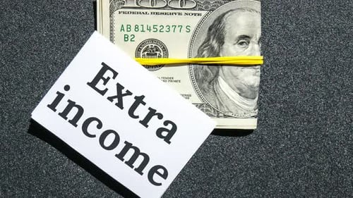 Aumente o zoom em dólares, dinheiro, dinheiro e papel, nota com texto escrito: RENDA EXTRA