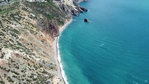 Aerial View From Above on Azure Sea and Volcanic Rocky Shores Small Waves on Water Surface in Motion