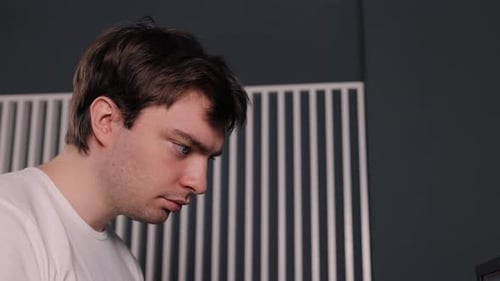 Young Adult Male Concentrating Indoors Close Up
