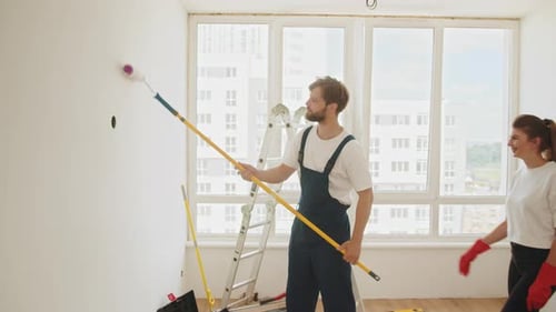 Man and Woman Painting Apartment Room Together