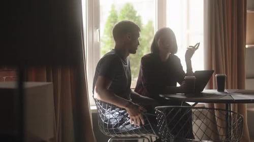 Two People Having a Business Meeting at a Coffee Shop Discussing Work