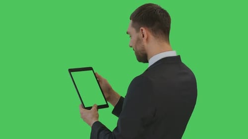 Medium Backview Shot of a Businessman Reading on a Tablet Computer. Tablet Screen and Background ar