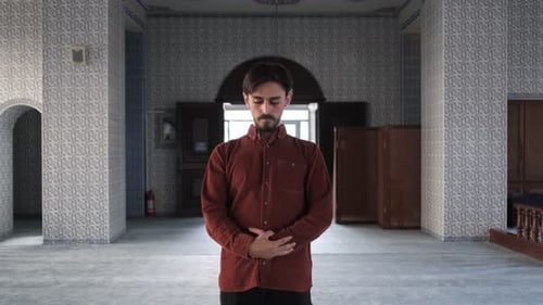 Vista frontal de um homem muçulmano barbudo em pé e dizendo Takbir para orar, o homem vai à mesquita para orar
