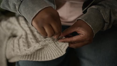 Hands of Black Woman Sewing Button on Clothing during Financial Hardship