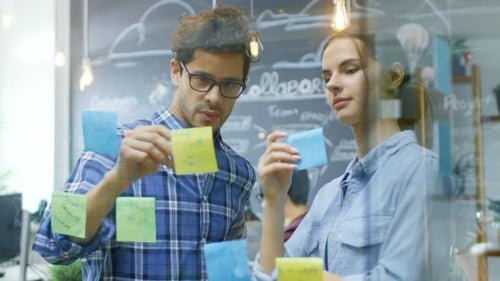 Team Brainstorming on Sticky Notes in Modern Office