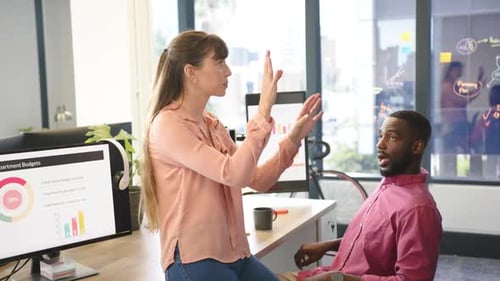 Discussing project, diverse colleagues analyzing charts on computer screens in modern office