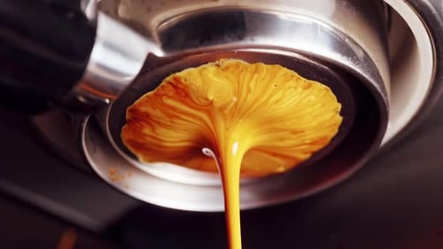 Leaking bottomless portafilter during espresso extraction caused by excessive pressure, macro view