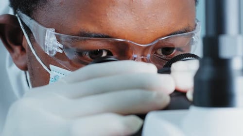 Ultra Macro Close Up Footage of a Male Scientist Wearing Medical Mask and Looking Into the