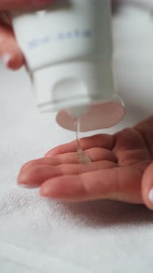 A esteticista está dispensando gel hidratante em sua mão em um spa - Close Up