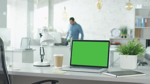 Creative Office Shot of Green Screened Laptop Standing on the Table with Nobody Working on It. In t