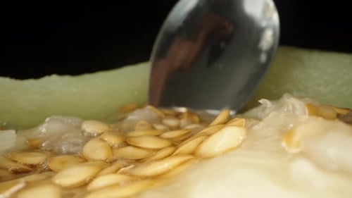 Des os et du jus à l'intérieur du melon, je ramasse les os avec une cuillère. Dolly Slider en très gros plan.