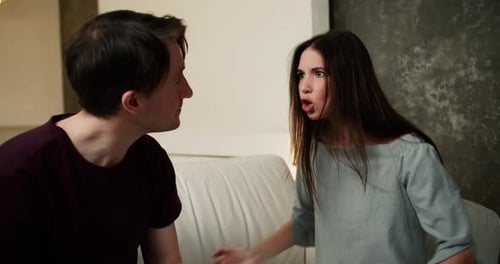 Couple Arguing on a Couch Indoors During the Daytime