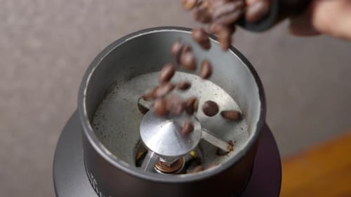 Kaffeebohnen gelangen in die Kaffeemühle. Nahaufnahme