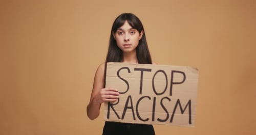 Woman Holds Stop Racism Sign in Studio