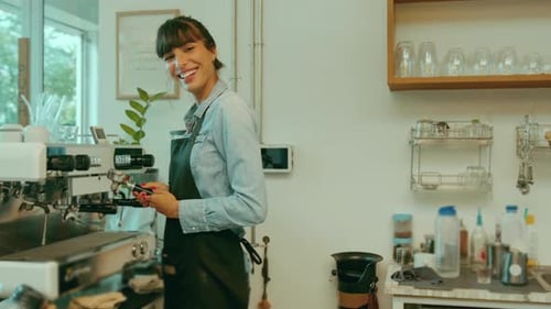 Young service minded barista woman working in coffee shop