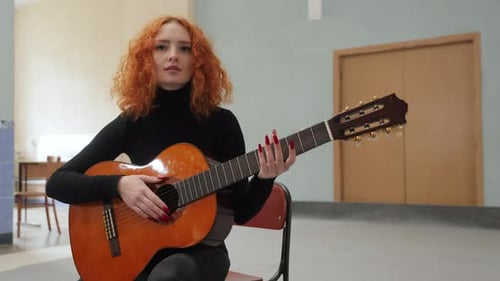 Woman Playing Classical Guitar in Room