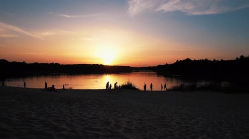 Aerial View of a Family Vacation on the Lake and a Beautiful Orange Sunset with Silhouetted Trees on