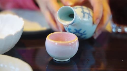 Japanese Sake Being Poured into Cup by Women, Close up Shot 4k