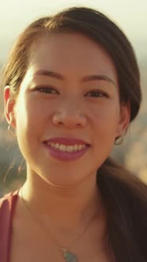 Close-up of young smiling woman standing outside