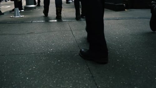 Following Close-up Shot of Man's Legs Walking on a Busy Big City Sidewalk.