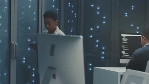 Technician Reviews Server Security IT Specialist Analyzing Security Alerts in Data Center