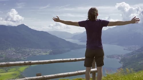 Man Enjoys Mountain View with Arms Outstretched