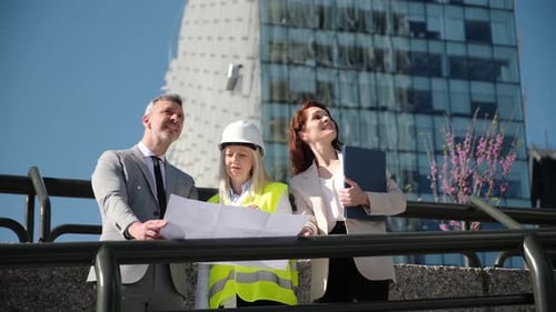 Architects Reviewing Building Plans at Construction Site