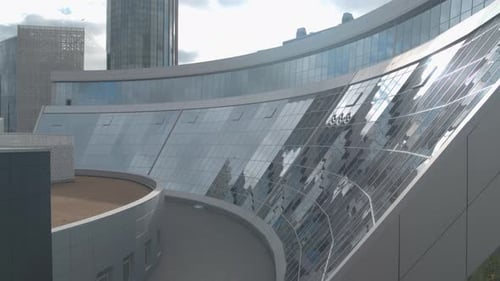 Flying Above Glass Facade Building on a Blue Cloudy Sky Background Stock Footage Office Building in