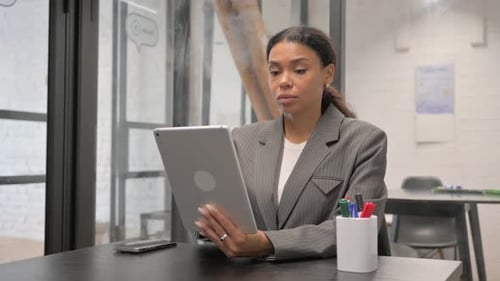 Woman Using Tablet in Bright Office Setting