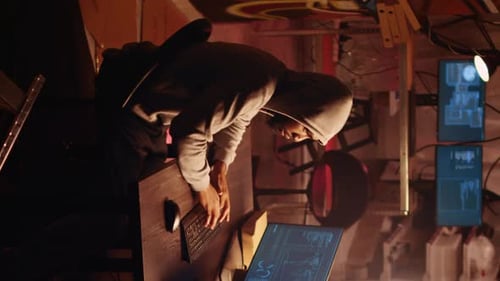 Young Adult Coding on Computer in Dimly Lit Room