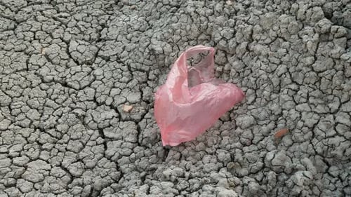 Una bolsa de plástico vuela en tierra seca: desastre ambiental