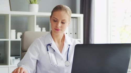 Doctor Works in the Medical Office Woman in White Coat Workplace of a Professional Female Therapist