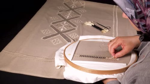 Woman Embroidering Intricate Designs on Tablecloth