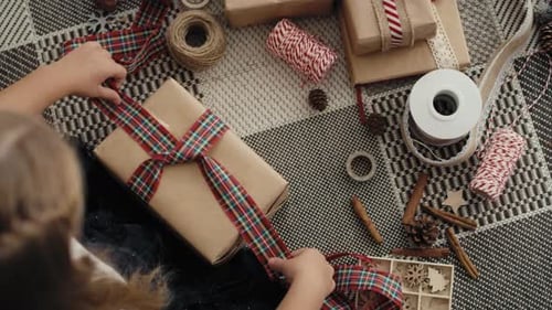 Top view of caucasian little girl wrapping Christmas gifts on the floor. Shot with RED helium camera