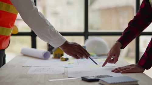 Architects Discussing Plans at a Wooden Table