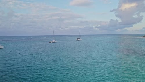 Tourist Anchored Catamarans Revealing Sunset in Crystal Clear Waters of Dominican Republic