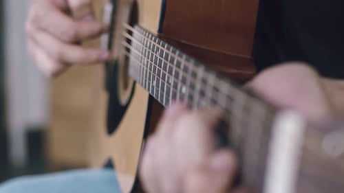 Hands Playing an Acoustic Guitar Close Up