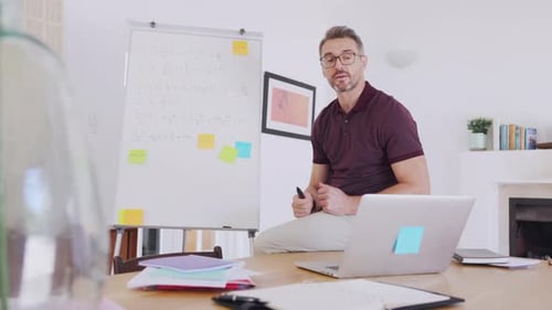 Man Explains Math on Whiteboard at Home