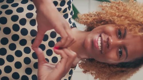 Smiling Woman Making Heart Shape with Hands