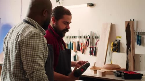 Two Men Collaborate on Woodworking Project in Workshop