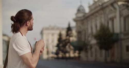 Male Tourist Taking Photos on City Street During Trip