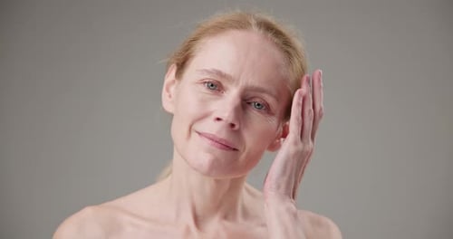 Smiling Woman Touches Her Face in Studio Close-up