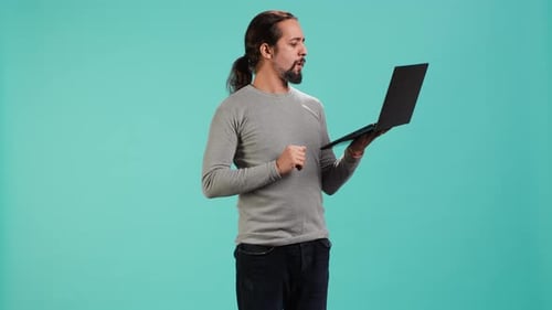 Man Composing Email Typing on Laptop Keyboard Excited to Log Off After Work
