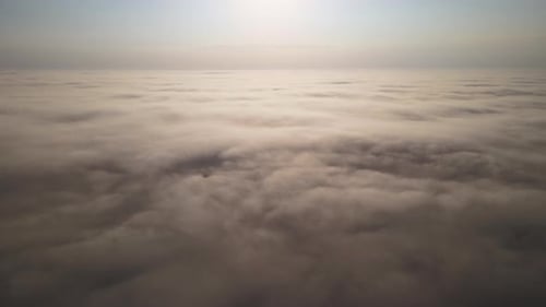 Aerial View From Above at High Altitude of Dense Puffy Cumulus Clouds Flying in Evening