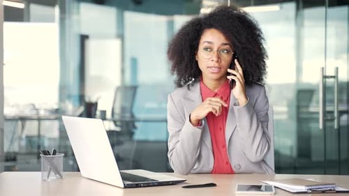 Professional Woman Talking on Phone at Desk