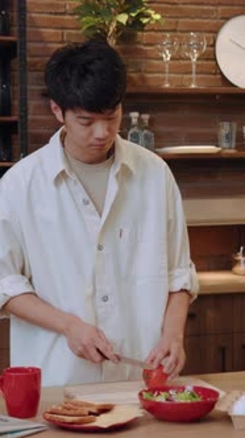 Young Adult Prepares Salad in Home Kitchen