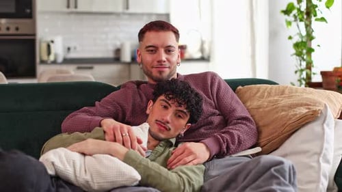 Affectionate Gay Couple Cuddling on Sofa at Home