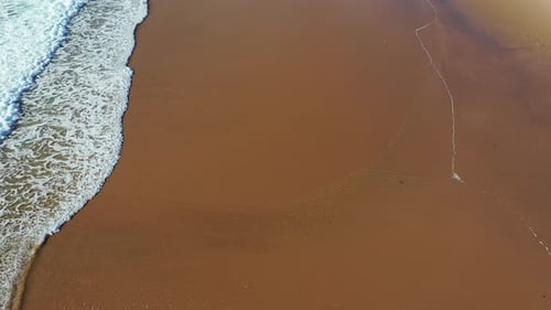 Tropical beach aerial view, Top view of waves break on tropical yellow sand beach. Sea waves seamles