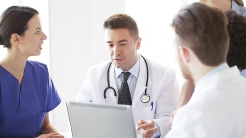 Medical Professionals Meeting Around Laptop in Bright Office