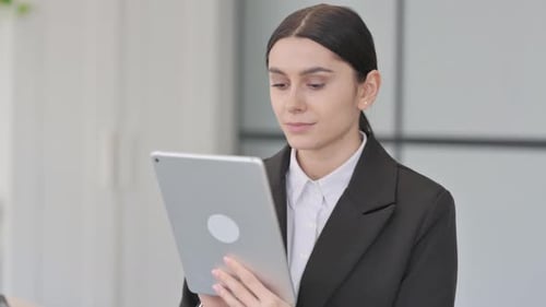 Young Woman Uses Tablet Device in Office